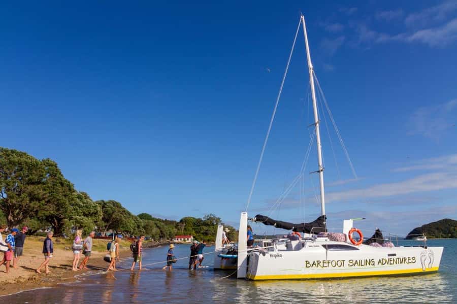 Bay of Islands 2-Hour Sundowner Evening Sailing Cruise - Boarding barefoot at Paihia Beach